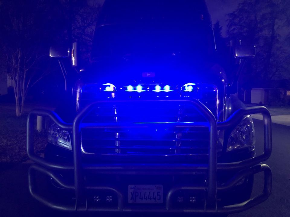 Semi-truck front at night with blue LED lights on the bumper bar